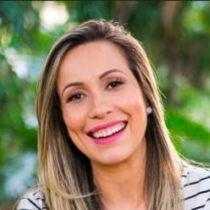 Hands typing at a laptop. On the screen, there is a page showing Hotmart Marketplace with courses to buy.