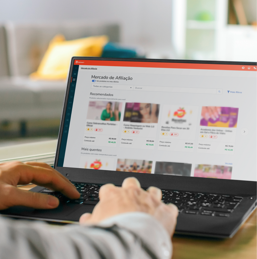 Hands typing at a laptop. On the screen, there is a page showing Hotmart Marketplace with courses to buy.