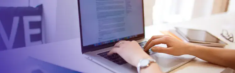 Hands typing on a laptop.